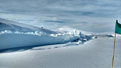 Green flag marks safe route to be taken on hikes in Antarctica, Pressure ridges making beautiful shape in Antarctica photo by Oindree Banerjee, used in blog how to phd, things to pack for antarctic expedition